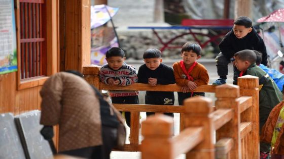 (211215) -- RONGSHUI, Dec. 15, 2021 (Xinhua) -- Students watch renovation of their classroom of the teaching point at Wuying Village, which lies on the border between south China's Guangxi Zhuang Autonomous Region and southwest China's Guizhou Province, on Dec. 9, 2021. With the support of Lianjiang City of Guangdong Province, the teaching point began to renovate classrooms, enrich libraries and build new toilets for a better studying environment. (Xinhua/Huang Xiaobang)